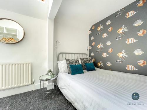 a bedroom with a bed with a large headboard at Sanderlings - holiday home close to beach in Weymouth