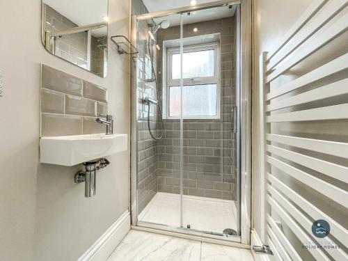 W łazience znajduje się prysznic i umywalka. w obiekcie Sanderlings - holiday home close to beach w mieście Weymouth