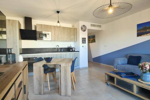 cocina y sala de estar con mesa y sillas en Bright apartment - sea view, en Fréjus