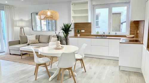 cocina y sala de estar con mesa blanca y sillas en The Cliffs - VilaTurquesa B, en Viveiro