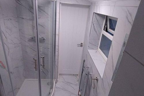 a shower with a glass door in a bathroom at Comfortable 2 Mins from River & 5 Mins From Town in Kempston