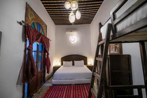 a bedroom with a bed and two bunk beds at Riad Fes Tala in Fez