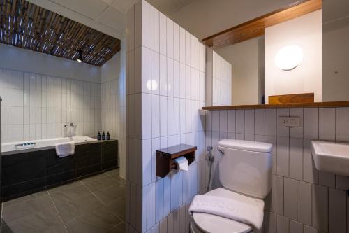 a bathroom with a toilet and a sink and a tub at RB Resort in Pattaya Central