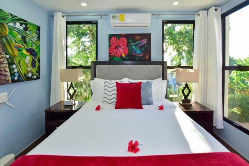 a bedroom with a large white bed with red pillows at Wagiya Flats in Hopkins
