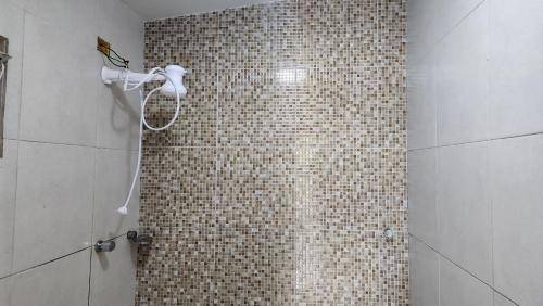 a shower in a bathroom with a tiled wall at Residencial Caetano em Porto de Galinhas in Porto De Galinhas