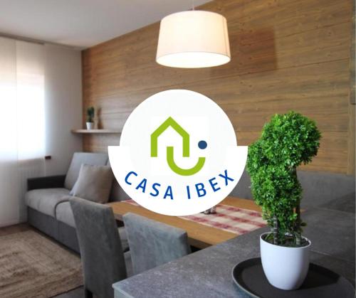 een woonkamer met een tafel met een potplant bij CASA IBEX - Piscina - Sauna - Baby Club in Cavalese