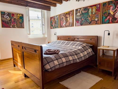 um quarto com uma cama de madeira e um cobertor xadrez em Art apartment Alla casa del Gastaldo em Gorizia