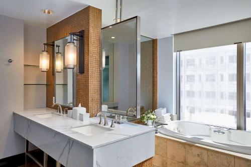 a bathroom with two sinks and a large mirror at Hotel 1000, LXR Hotels & Resorts in Seattle