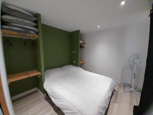 una piccola camera con letto e parete verde di Appartement Vieux-Boucau-les-Bains, 3 pièces, 4 personnes - FR-1-239-982 a Vieux-Boucau-les-Bains