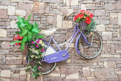 a purple bike with flowers on a brick wall at Villas Marianna in Kalavárda