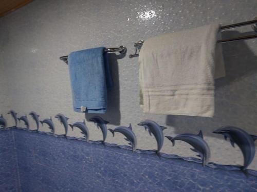 ein Badezimmer mit blauen Handtüchern und einem Spiegel in der Unterkunft The D'Lux Home, Homa Bay in Homa Bay