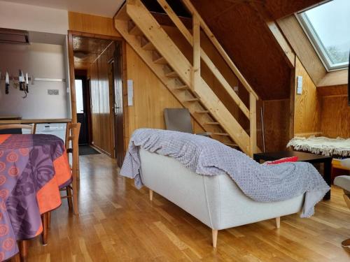 a living room with a couch and a staircase at Chalet climatisé grande terrasse parking privé in Coublevie