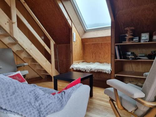 a living room with a skylight and a couch and a table at Chalet climatisé grande terrasse parking privé in Coublevie