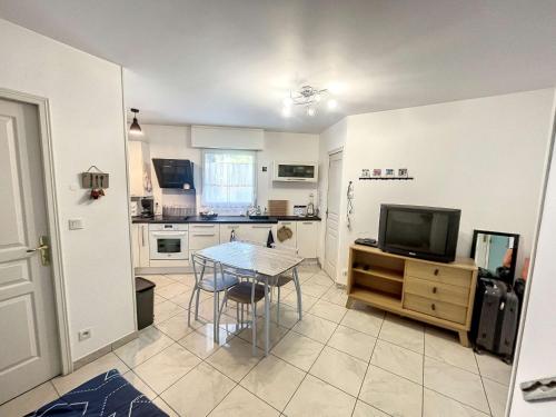 une cuisine avec une table et une télévision. dans l'établissement Appartement cosy à Granville, proche plage pour 2 personnes avec WiFi et parking - FR-1-361-517, à Granville