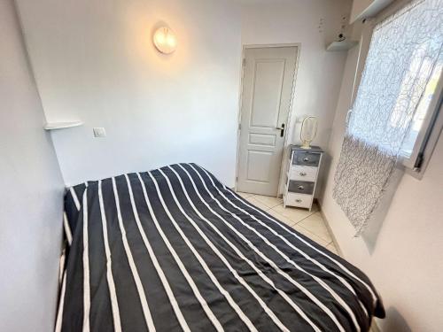 - une chambre avec un lit à rayures noires et blanches dans l'établissement Appartement cosy à Granville, proche plage pour 2 personnes avec WiFi et parking - FR-1-361-517, à Granville