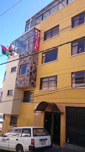 a building with a car parked in front of it at Bolivian Heights Hostel in La Paz