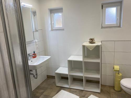 Baño blanco con lavabo y aseo en Almhaus Sankt Oswald, 
