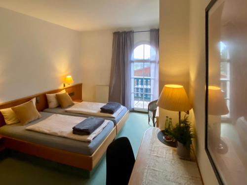 a hotel room with two beds and a window at Vanilla Hof in Naumburg