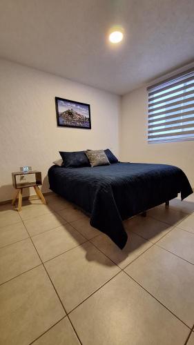 ein Schlafzimmer mit einem großen Bett und einem Tisch in der Unterkunft Departamento Vistas de Pátzcuaro in Pátzcuaro