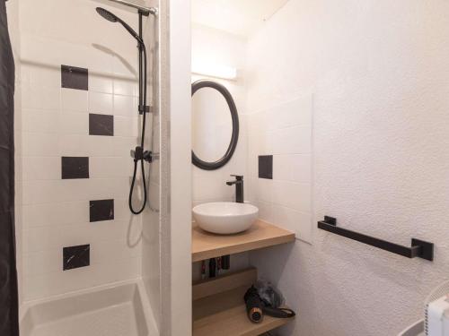 une salle de bain avec un lavabo et une douche dans l'établissement Charmant T2 avec balcon, coin nuit, kitchenette équipée et accès direct aux activités de montagne. - FR-1-400-120, à Eaux-Bonnes
