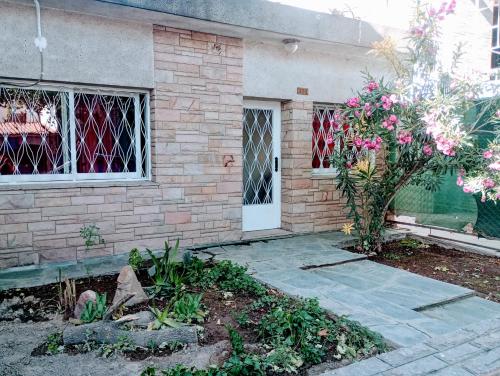 ein Backsteinhaus mit einer weißen Tür und einem Baum in der Unterkunft Casa Antigua 'LEON' in Mendoza