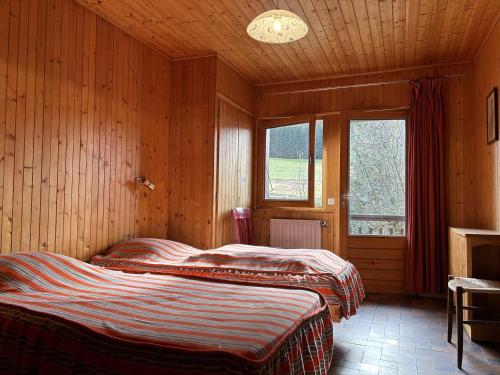 two beds in a room with wooden walls at Chalet Notre-Dame-de-Bellecombe, 8 pièces, 14 personnes - FR-1-595-93 in Notre-Dame-de-Bellecombe
