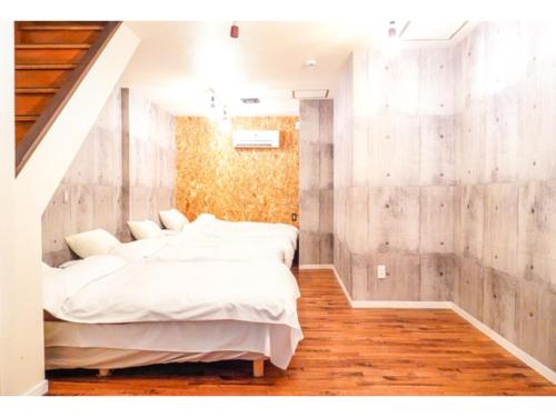 姫路市にあるONE Hostel Himeji - Vacation STAY 98707vの木製の壁のベッドルーム1室(ベッド2台付)