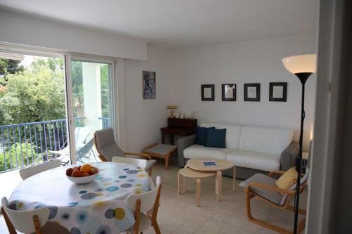 un salon avec une table et un canapé dans l'établissement Spacious apartment with balcony and sea view, à Antibes