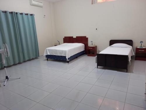 a hospital room with two beds and green curtains at Martin Barroso in Yacuiba