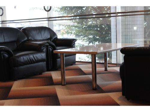 a coffee table and a couch in a room with a window at Hotel 1-2-3 Maebashi Mercury - Vacation STAY 07728v in Maebashi