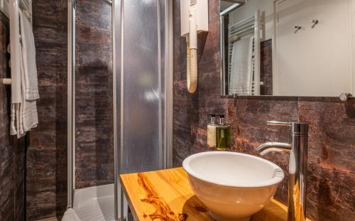 a bathroom with a bowl sink and a shower at Le Nouvel Hôtel in Oyonnax