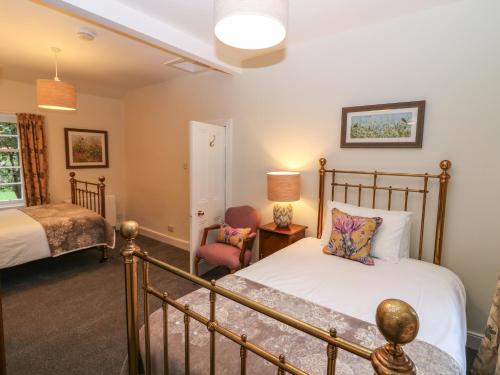 a bedroom with a bed and a chair at Middle Cottage - Tarvit in Cupar