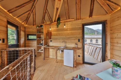 - une cuisine dans une cabane en bois avec une grande fenêtre dans l'établissement ESCALE CAB'ÂNE, à Mittlach