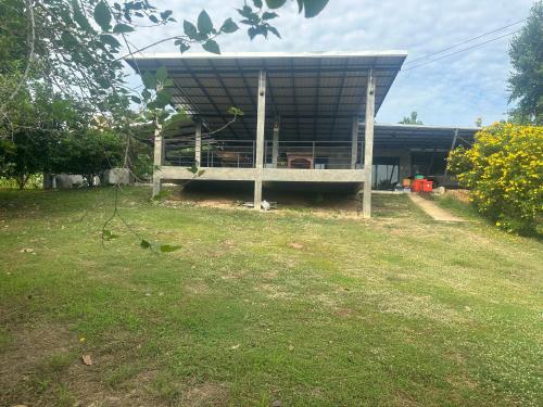 a house with a porch in a yard at ชลลดา ริเวอร์ โฮมสเตย์ แก่งกระจาน in Ban Wang Malako