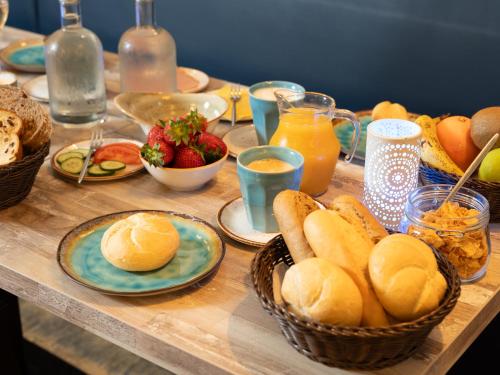 a table topped with baskets of bread and fruit at Hotel de Burg in Domburg