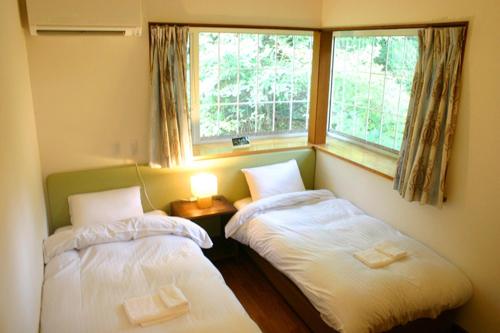 two twin beds in a room with a window at Windy Hill Morinoyado - Vacation STAY 07709v in Yamanakako
