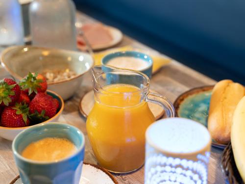 a table with plates of food and a glass of orange juice at Hotel de Burg in Domburg