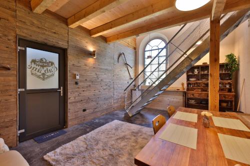 a dining room with a table and a staircase at ESCALE CAB'ÂNE in Mittlach