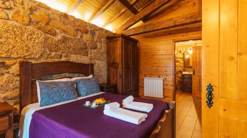 een slaapkamer met een bed in een stenen muur bij Casa do Guardião do Castelo in Arnoia