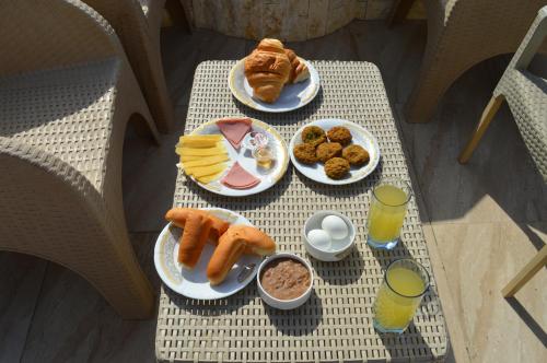 a table with plates of breakfast food on it at Pyramids Orion inn in Cairo