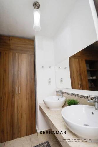 a bathroom with two sinks and a mirror at Departamento con amenidades in Cancún