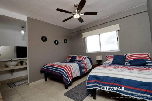 a bedroom with two beds and a ceiling fan at Departamento con amenidades in Cancún