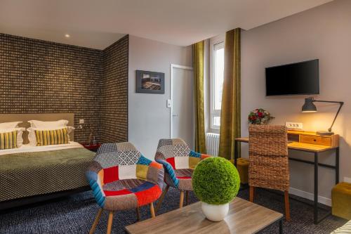 a hotel room with a bed and a living room at Le Nouvel H&ocirc;tel in Oyonnax