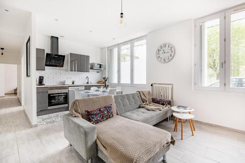 uma sala de estar com um sofá e uma cozinha em Le Steel-Appart Cosy tout neuf-WIFI-NETFLIX em Terrenoire