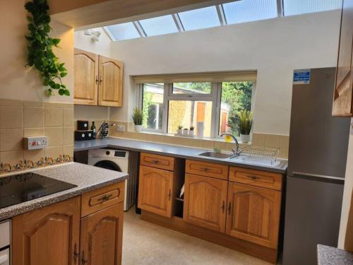 a large kitchen with wooden cabinets and a window at Lovely Spacious Stays in Cambridge