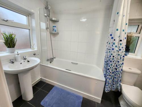 een badkamer met een bad, een wastafel en een toilet bij Lovely Spacious Stays in Cambridge