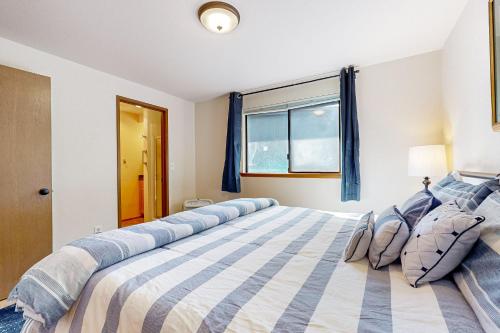 a bedroom with a large bed with blue and white stripes at Tahlequah Inn in Grapeview