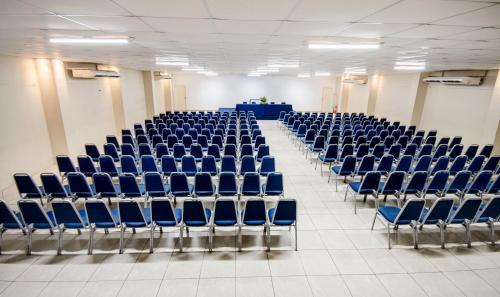 an empty room with blue chairs in a lecture hall at Hotel Jangadeiro in Recife