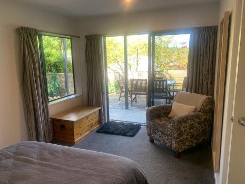 um quarto com uma cama, uma cadeira e uma janela em 41 St James Avenue em Hanmer Springs