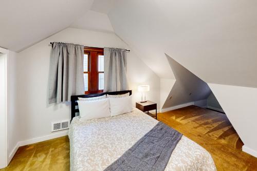 a white bedroom with a bed and a window at Sunnyside Up in Seattle